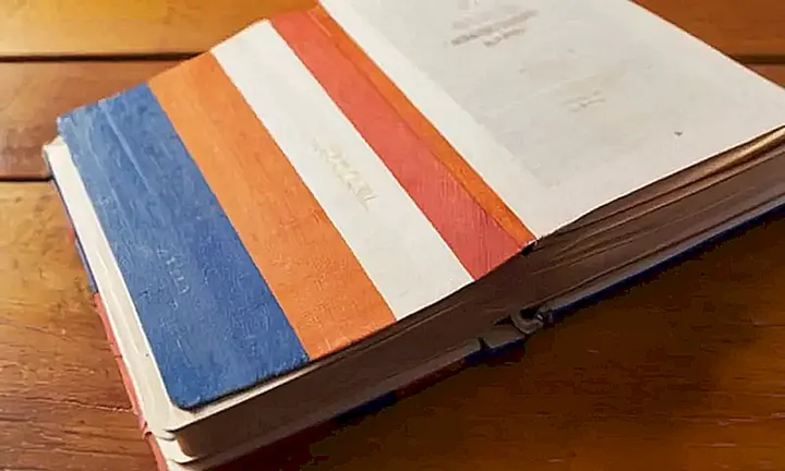 Un libro de guía de ciudadanía está abierto sobre una tableta con un símbolo de la bandera de España en su cubierta