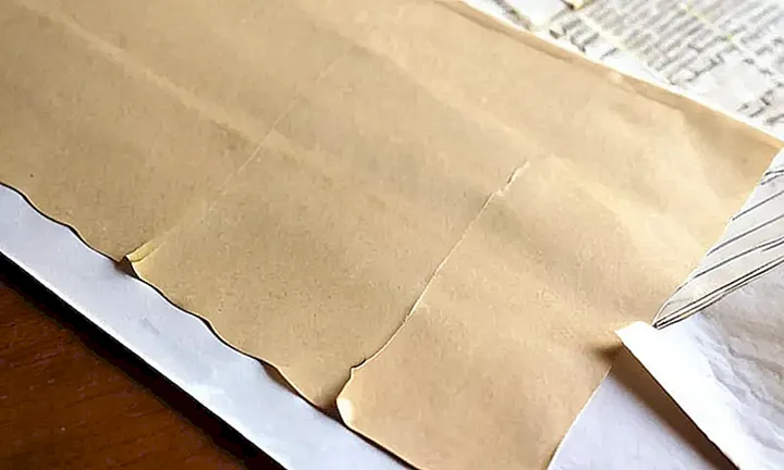 La escena describe un escritorio desordenado donde se encuentra un papel estragado con recuerdos personales y documentación administrativa