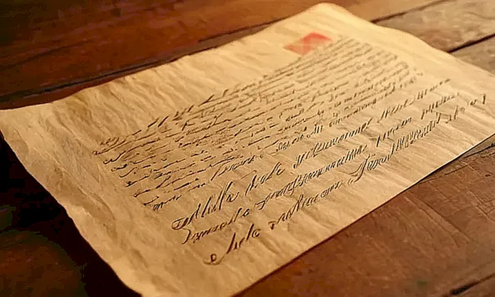 Un documento de papel viejo y arrugado con textos manuscritos en varios colores y estilos, abandonado sobre una mesa de madera con imágenes borrosas de un escudo español al fondo