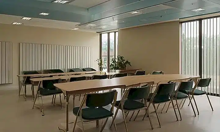 Una habitación de examen con iluminación suave y calida, muebles de madera clásicos y un ventanal que deja entrar luz natural