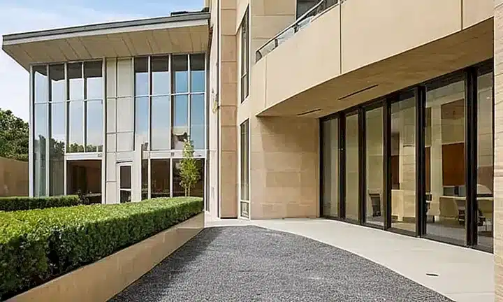 El edificio de Nueva Ciudadanía es un espacio elegante con una fachada blanca y verdejo rodeada por un cortil tranquilo, donde se puede apreciar la serenidad del lugar reflejando los movimientos pacíficos y tranquilos de las personas