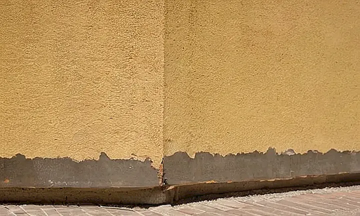 La pared tiene un defecto de unos 2-3 cm cerca del rincón superior izquierdo, cubierto por una pancarta municipal deformada