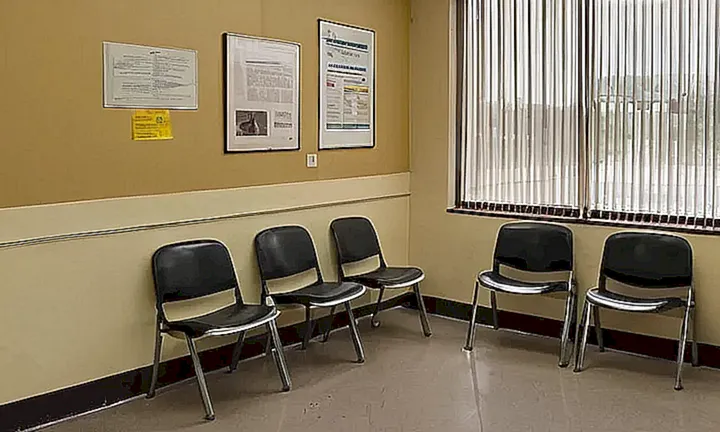 Una oficina espera area con muebles de plástico sucios y un olor a polvo y aire viciado