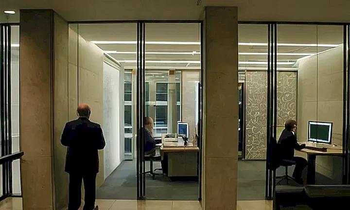El interior moderno de un edificio gubernamental cuenta con paredes de concreto descubierto, cámaras de visión 360 grados y una iluminación intensa que destaca la arquitectura