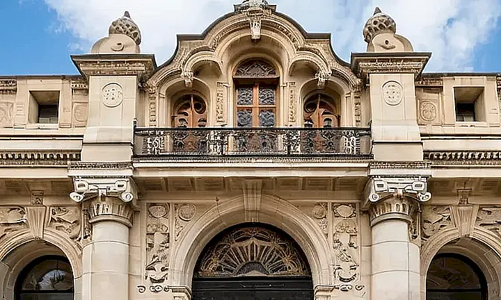 El edificio del ayuntamiento presenta un exterior elegante con una fachada de colores suaves y detallados molduras en piedra