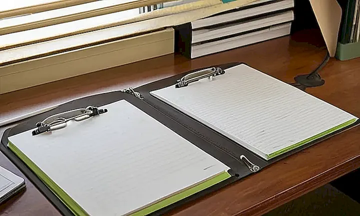 La imagen describe un espacio de trabajo antiguo y utilizado con detalles como etiquetas desgastadas, luces fluorescentes y una iluminación natural que destaca los detalles del escritorio