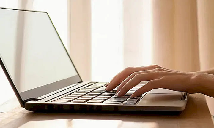 Una mujer joven trabaja con su laptop en un escritorio Minimalista bañado en la luz suave del amanecer
