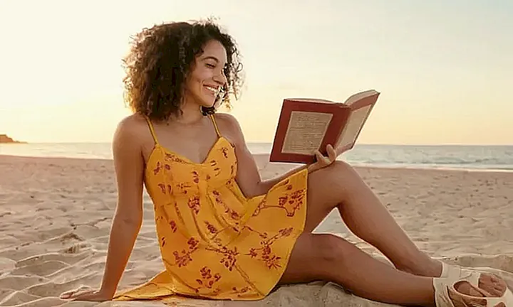 La página web presenta un gran Banner con el título Ley de Ciudadanía Española sobre un patrón decorativo español, acompañado de una foto de una joven mujer con un libro en la playa y dos iconos laterales