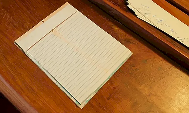 Un formulario oficial gastado y amarillento se encuentra extendido sobre un escritorio de madera, iluminado por la luz del atardecer