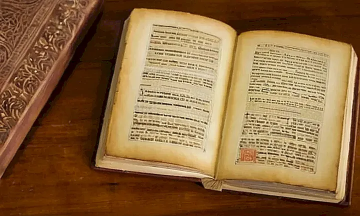 En un escritorio de madera se encuentra un libro arrugado con una página abierta, donde una antigua carta detalla leyes de ciudadanía española y está al lado de las modernas políticas de Ius Soli