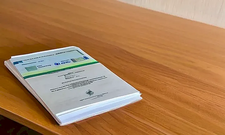 Una foto de papeles blancos doblados y varios documentos en la mesa de un cuarto con iluminación suave