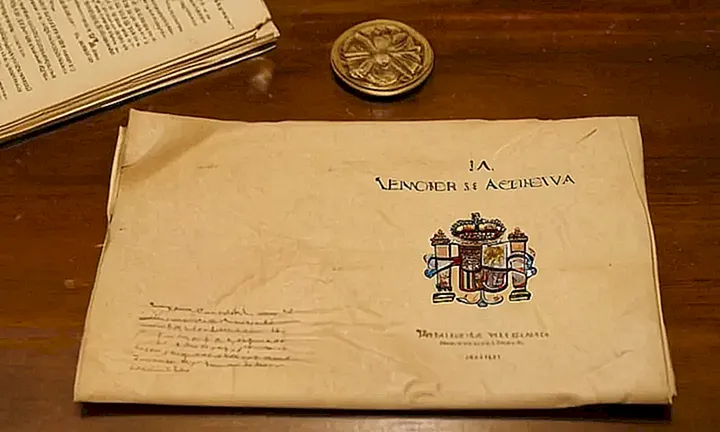 Un documento desgastado reposa sobre una mesa antigua y desordenada bajo una luz cálida que hace danzar los polvos en el aire