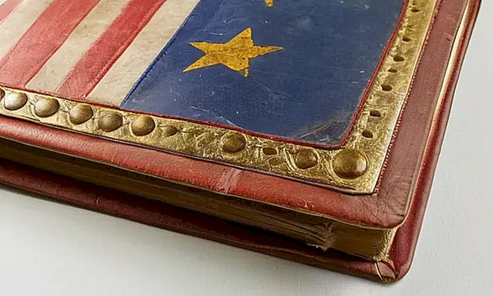 El libro tiene una vieja cubierta de cuero con título en oro y una bandera española gastada en la esquina superior izquierda