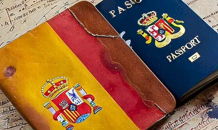 Un pasaporte desgastado de cuero se abrió sobre una mesa atestada mostrando un escudo de la bandera española algo desteñida