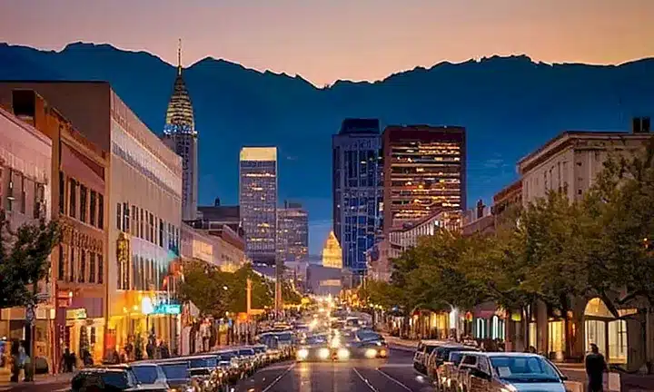 El paisaje urbano refleja una mezcla de modernidad y tradición en un entorno rodeado por montañas nevadas