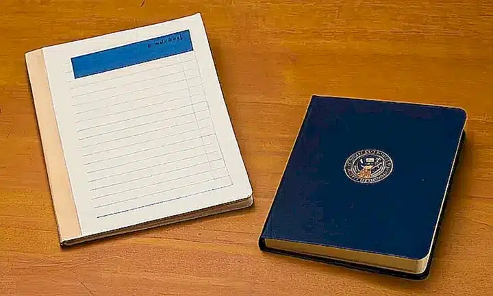 La mesa desgastada sostiene un montón de documentos con diferentes texturas y formatos