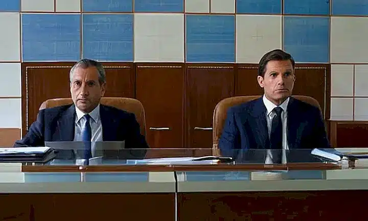 Dos hombres mayores en susajes nórdicos observan un expediente exhaustivo en una mesa simple