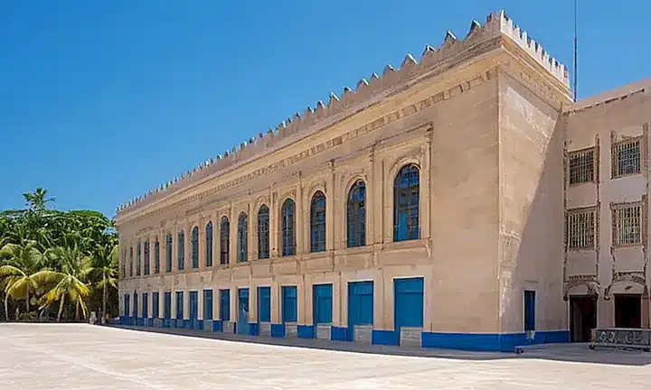 El edificio gubernamental tiene una fachada de piedra caliza desgastada en tono beige que se encuentra en un cielo tropical