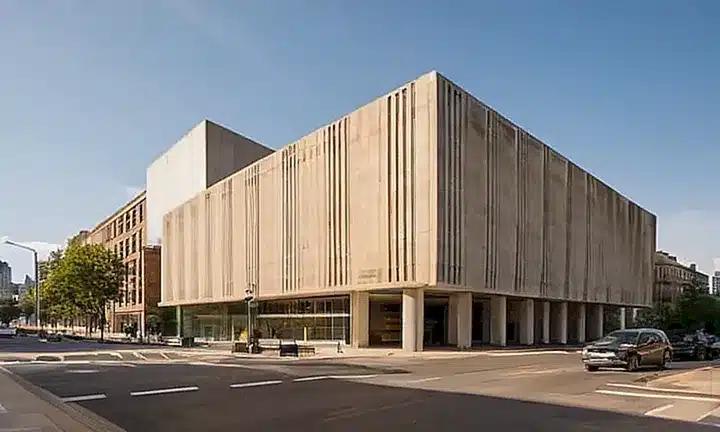 Un edificio gubernamental desgastado se ergue en el centro de una ciudad moderna y concurrida