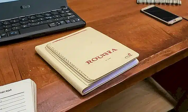 Una mesa de madera desordenada con documentos y papeles caóticos es ilustrada ligeramente por una luz suave