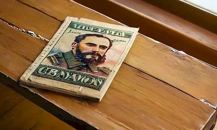 Una caja de libro desgastada descansa en una mesa con un fondo claro, rodeada por un ambiente clásico y anticuado
